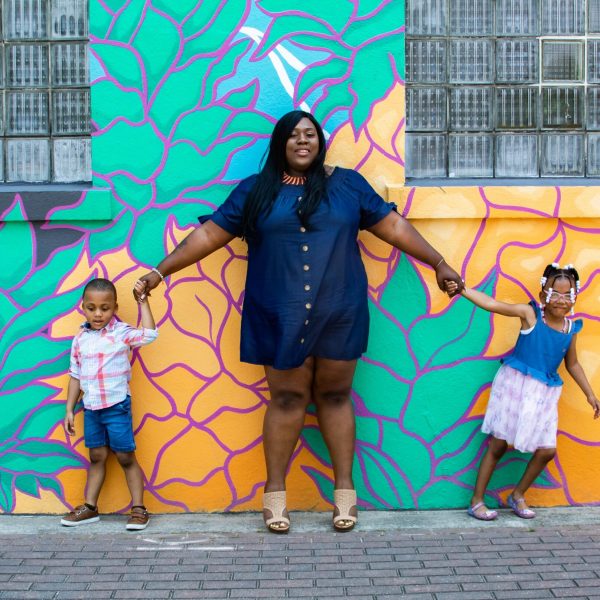Mother in front of mural with 2 children